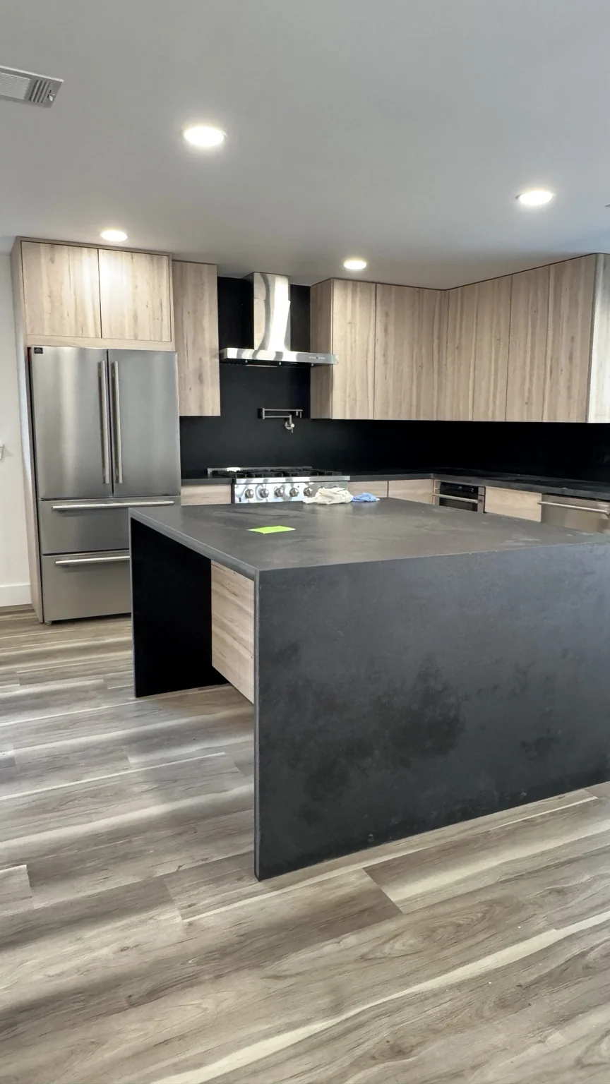 Modern kitchen with light wood cabinets and dark island