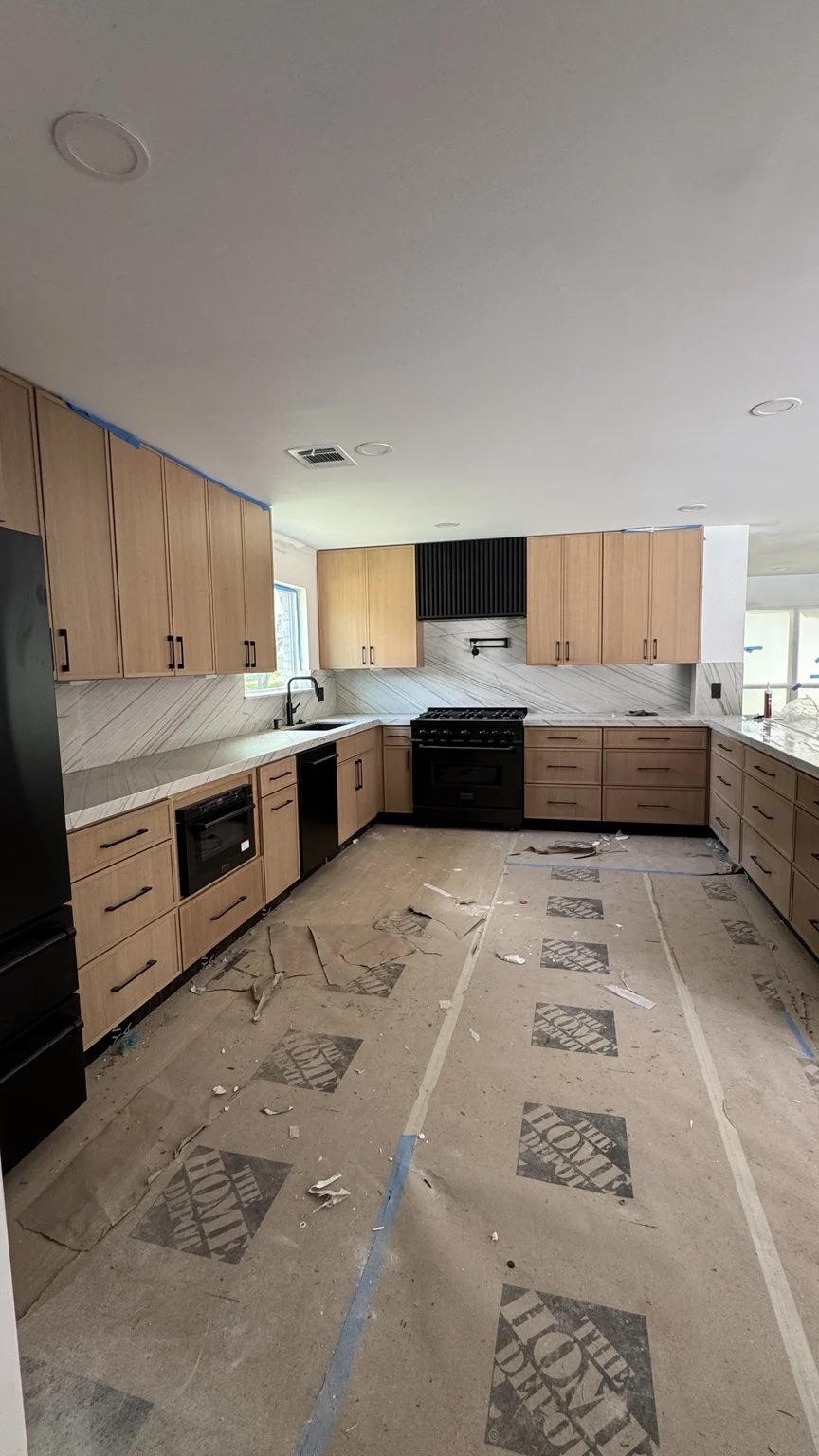Kitchen renovation with natural wood cabinetry and marble-look island, work in progress